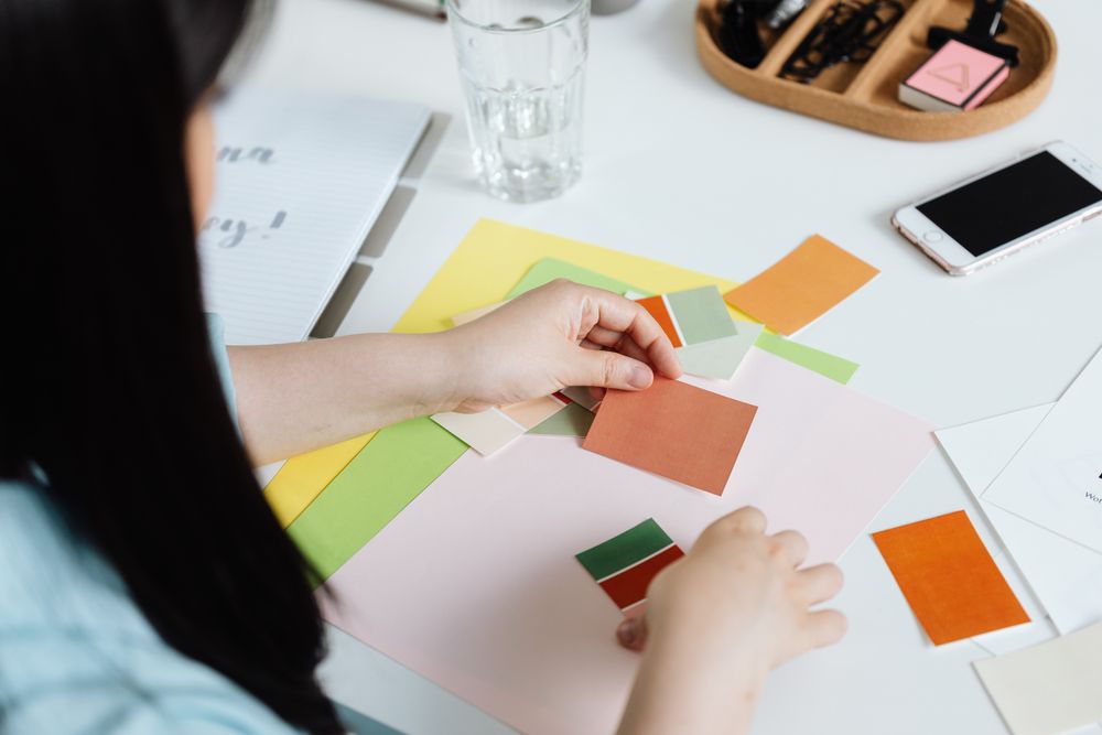 Mãos organizando amostras de cores para um projeto visual